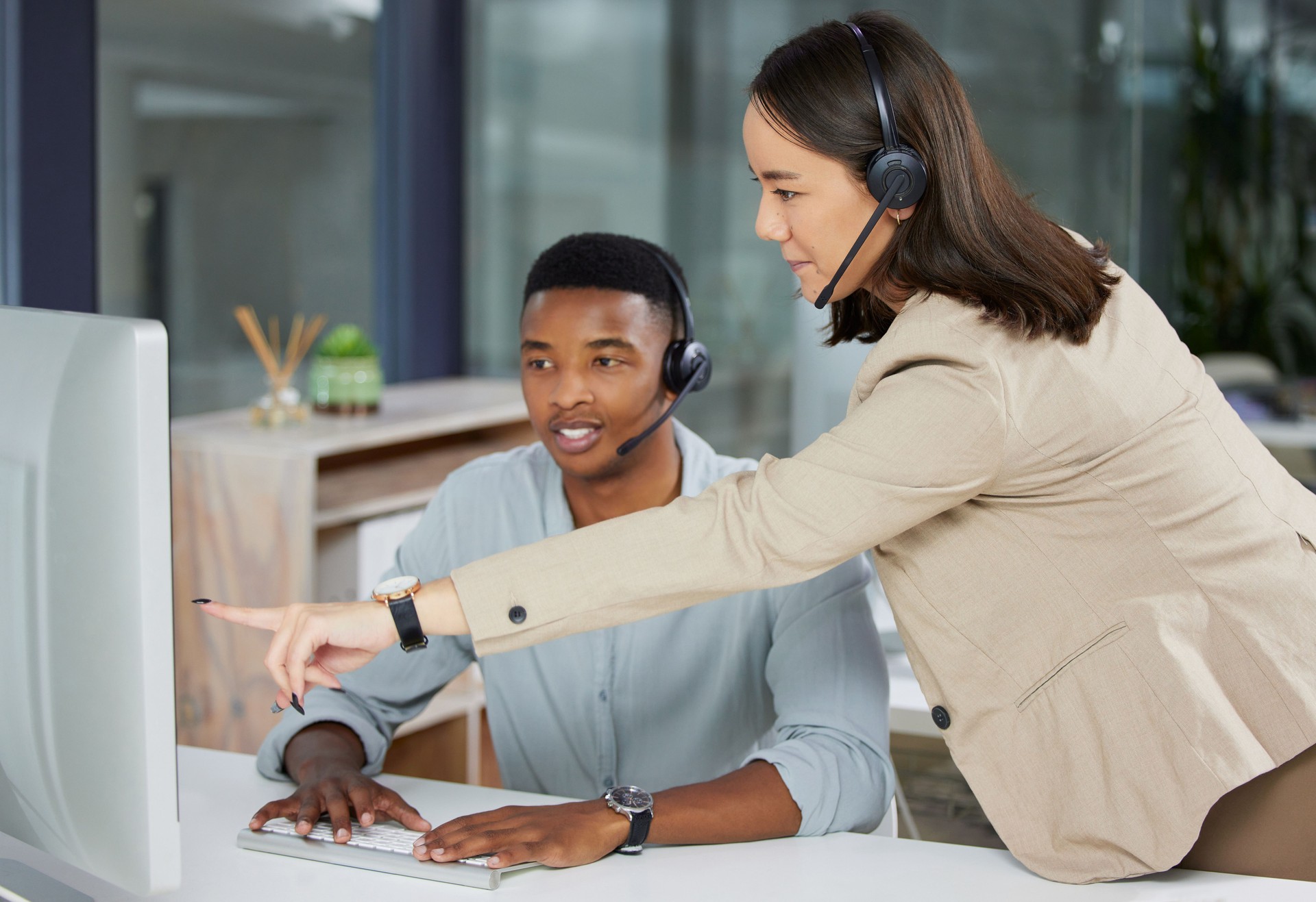 Shot of a young man and woman using a computer while working in a call centre